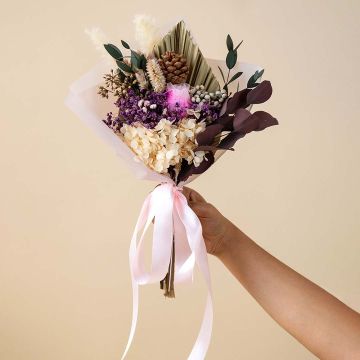 Elegant preserved bouquet on a white background featuring hydrangea infinity rose eucalyptus pampas grass and pine cone.
