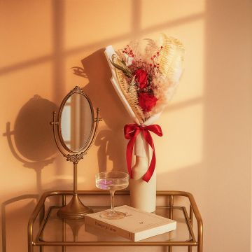 Infinity Rose Red bouquet displayed in hand-tied arrangement with preserved flowers red hydrangea and eucalyptus.