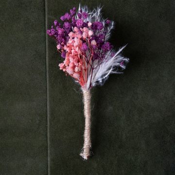 Closeup of preserved dried flower bouquet with purple and pink blooms wrapped in jute – rustic artificial flower arrangement.