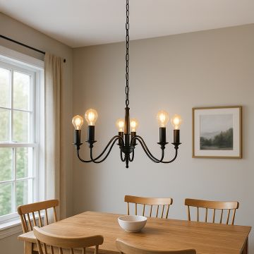 Elegant black metal chandelier with curved arms and exposed Edison bulbs hanging in interior space creating vintage lighting.