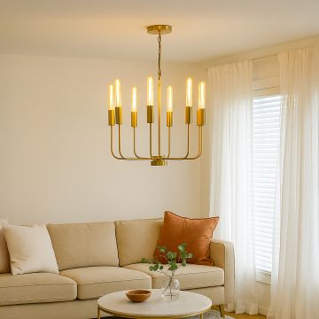 Elegant brass gold chandelier with eight exposed Edison tube bulbs hanging in interior space creating luxurious vintage lighting.