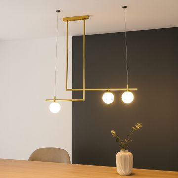 Gold pendant light with three glowing glass globes hanging stylishly above dining table for modern home interior decor.