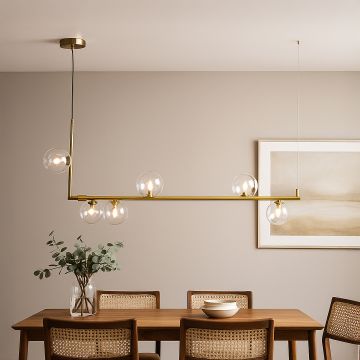 Modern gold linear chandelier with clear glass globes styled in a bright room creating elegant ambient lighting.