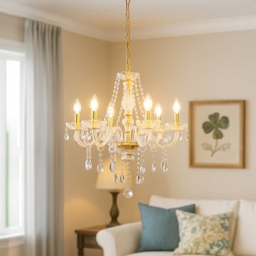 Gold crystal chandelier glowing warmly in modern living room with sofa wall art and soft elegant interior decor.