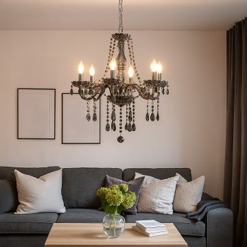 Smoky grey chandelier with crystal droplets glowing above sofa in living room for elegant luxury home lighting.