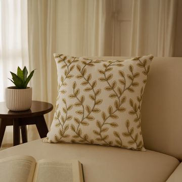 Soft cotton cushion cover with golden botanical pattern placed on a beige sofa offering a warm stylish décor accent with a gentle breathable and skin friendly material.