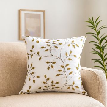 White cotton cushion cover featuring golden botanical leaves styled on a sofa adding a warm natural décor accent with a smooth breathable and skin friendly fabric finish.