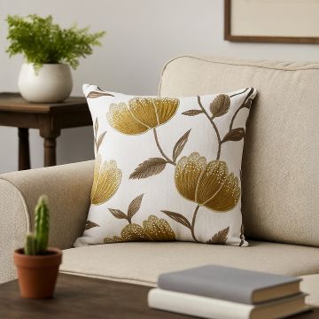 Cotton cushion cover with a large golden botanical design placed in a modern living room bringing a luxe nature inspired décor element with a soft comfortable skin friendly texture.