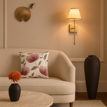 Soft cotton cushion cover with brown floral embroidery displayed on a curved sofa offering a warm organic décor accent with a breathable smooth and skin friendly fabric texture.