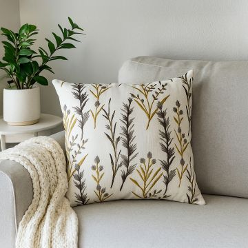 Cotton cushion with yellow and grey embroidered botanical pattern placed on a soft grey sofa creating a cozy lifestyle decor accent for modern living spaces.