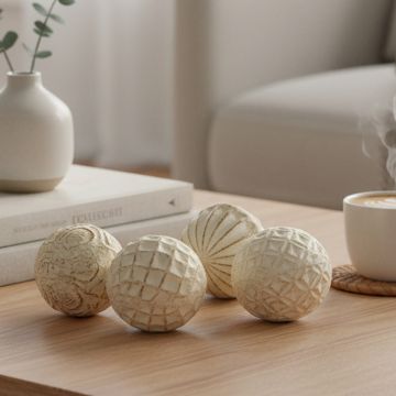Textured ceramic balls set styled on a wooden coffee table beside a cup of coffee and books in a cozy minimal living room.
