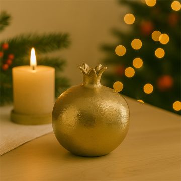 Golden pomegranate decor piece displayed in a warm lifestyle setting highlighting its rich textured seeds and polished finish