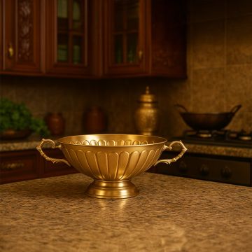 A golden decorative tray displayed on a dark wooden table inside a traditional interior with carved arches soft seating and warm ambient lighting creating an elegant scene.