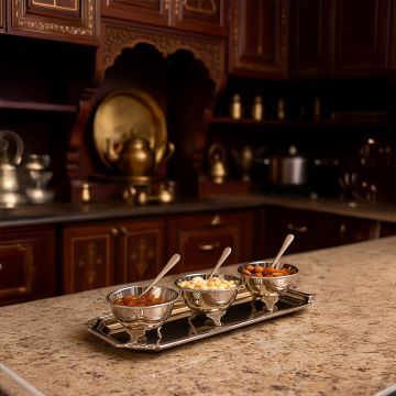 Elegant silver condiment bowl set displayed in a luxurious kitchen setting highlighting intricate detailing and a refined traditional ambience.