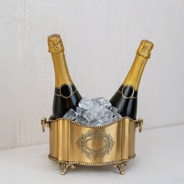 A brass champagne bucket holding two bottles with ice displayed on a clean surface creating an elegant lifestyle setting with a refined festive look.
