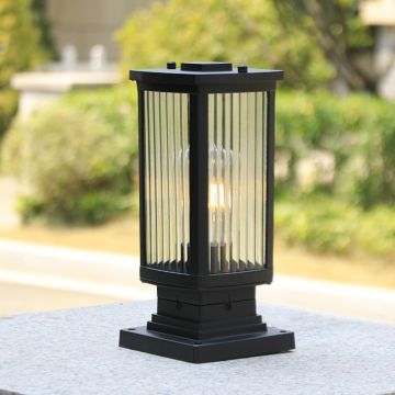 Elegant black outdoor pillar lamp with frosted glass glowing warm light for patio balcony and garden decor.