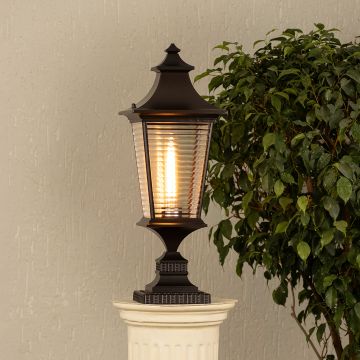 Black metal outdoor post lantern Light On on a stone gate pillar Traditional style Main Lifestyle image.
