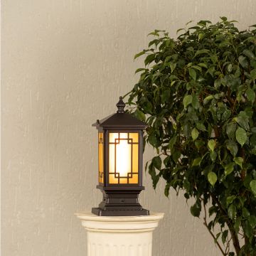 Black metal outdoor post lantern Light On on a stone gate pillar Traditional style Main Lifestyle image at night.