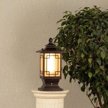 Black metal outdoor post lantern Light On mounted on a stone pillar Traditional garden gate lighting Main Lifestyle image at night.