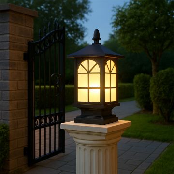 Black metal outdoor post lantern Light On mounted on a stone pillar Traditional garden gate lighting Main Lifestyle image at night.