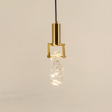 Contemporary hanging light with crystal-like glass shade and gold-toned metal base glowing softly against a white background perfect for modern decor.