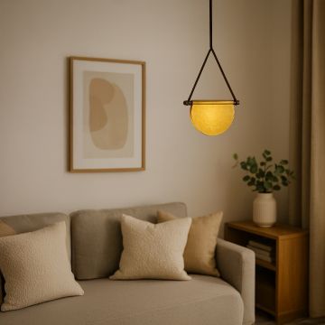 Warm-toned pendant light with yellow half-moon glass shade and brown frame styled in a modern setting adding a soft ambient glow.