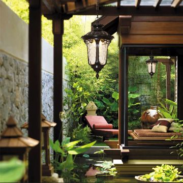 Elegant black metal outdoor hanging lantern light on creating warm ambient glow in a lush garden retreat perfect for patio and walkway Decor.