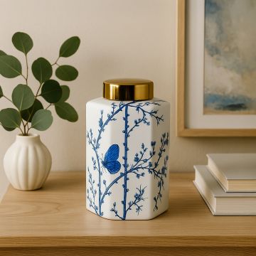 Elegant blue and white ceramic jar with butterfly and floral design styled on table adding luxury charm to decor."
