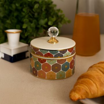 Colorful geometric ceramic jar with crystal knob lid styled on tabletop adding vibrant charm to luxury home decor.