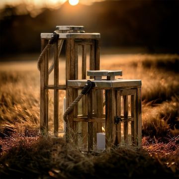 Wood lantern placed in outdoor setting during sunset for elegant warm ambiance and rustic garden décor