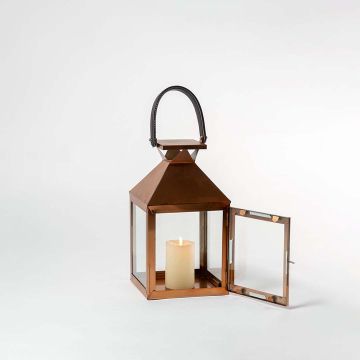 Handcrafted copper lantern on white background showing its polished metallic surface transparent glass sides and sturdy black handle — a perfect accent piece for modern and rustic home interiors.