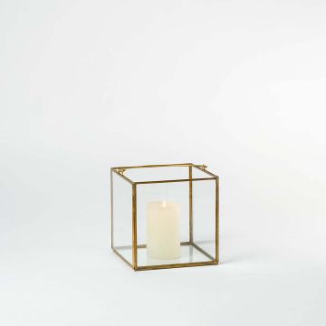 Cube glass box with golden metal frame styled in modern living room decor for elegant storage and home decoration.