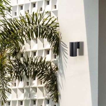 Black metal cylindrical outdoor wall light adding modern minimal style to exterior walls for sleek contemporary home decor.