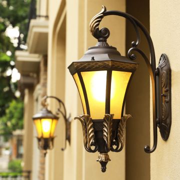 Elegant outdoor wall light with vintage lantern design glowing warmly on exterior wall perfect for home entrance decor.