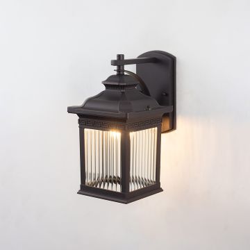 Lantern wall light on white background with glass panels illuminated highlighting classic design.