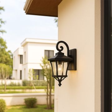 Outdoor lantern wall light illuminating a modern home exterior.