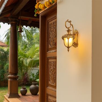 Antique outdoor wall light illuminating a traditional entrance with carved wooden door and elegant exterior decor.