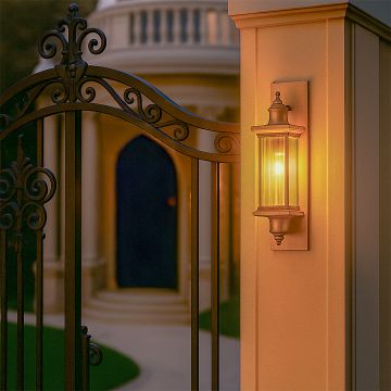A warm glowing outdoor wall light mounted beside an ornate gate creating an inviting evening ambience with its light on and highlighting elegant architectural details.