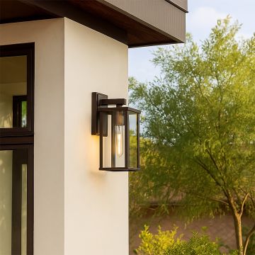 Modern bronze metal outdoor wall light with clear glass panels light on illuminating a contemporary home exterior perfect for porch patio and entryway Decor.