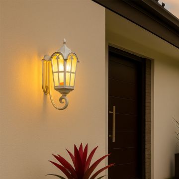 White metal outdoor wall lantern light on with textured glass panels creating warm welcoming illumination for a modern home entrance porch patio and pathway Decor.