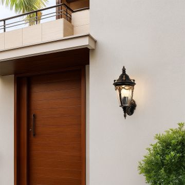 Bronze outdoor wall lantern with the light on mounted beside a wooden entrance door creating a warm inviting glow and enhancing elegant exterior home styling.