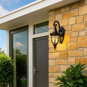 Elegant outdoor wall lantern styled in a lifestyle setting with ornate black details and warm amber glass panels.