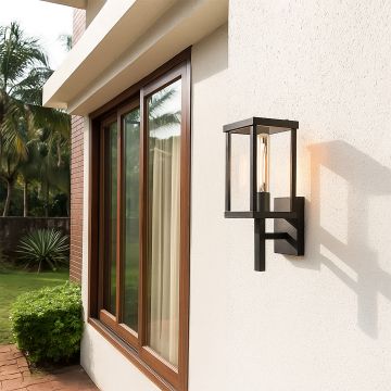 Modern black metal outdoor wall light glowing softly beside large windows adding warm elegant lighting to garden and patio spaces.