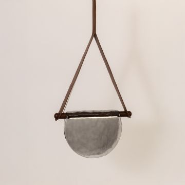 Pendant light with grey half-moon textured glass shade and brown frame illuminated on a clean white background for a bright modern look.