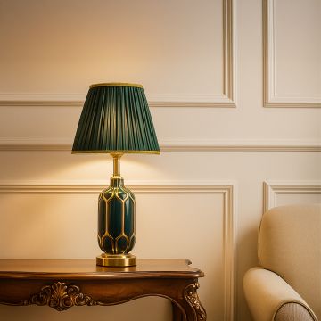 Sophisticated table lamp with an emerald patterned ceramic base metal accents and a pleated green shade giving warm light for elegant living room decor.