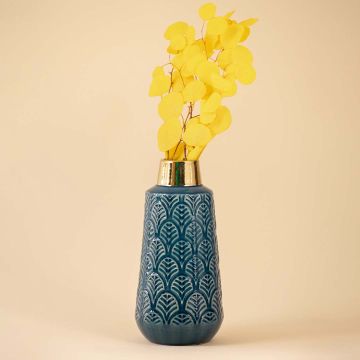 A blue ceramic vase with detailed leaf pattern and reflective gold neck shown on a white background highlighting its artistic design.