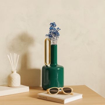 Teal ceramic vase with gold handle styled in a modern interior perfect for consoles shelves and elegant contemporary home decor accents.