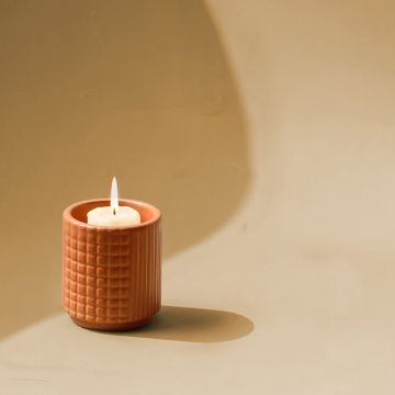 Terracotta ceramic textured candle holder displayed on a clean white background ideal for modern home and table decor.