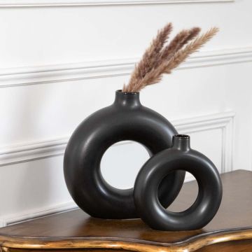 Set of two black ceramic donut vases with matte finish modern round hollow design styled for pampas grass decoration.