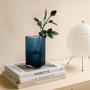 Ribbed blue glass vase placed on a modern console or table bringing a refreshing accent to contemporary home interior styling.